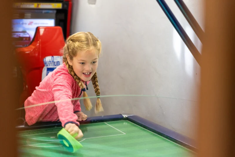 Girl enjoying Park Cliffe's indoor games room