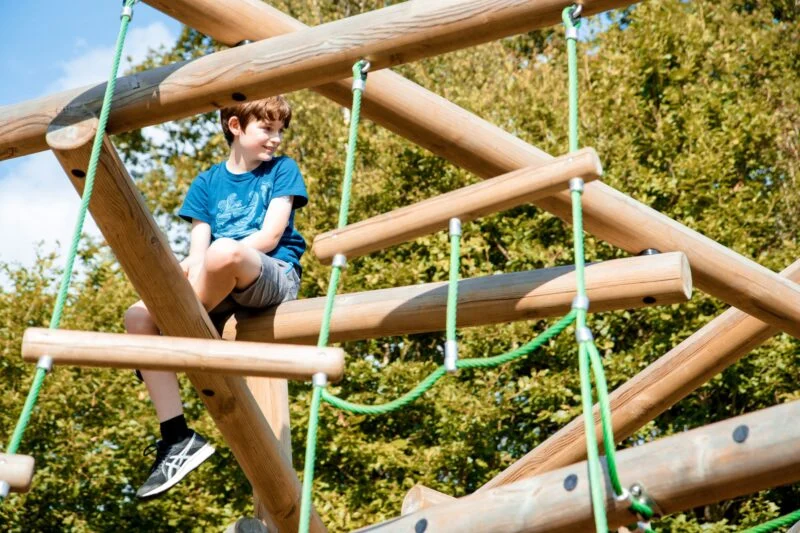 boy on climbing frame at park cliffe
