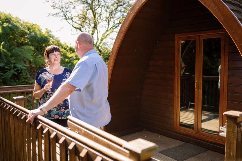 camping pod balcony couple wine Lake District