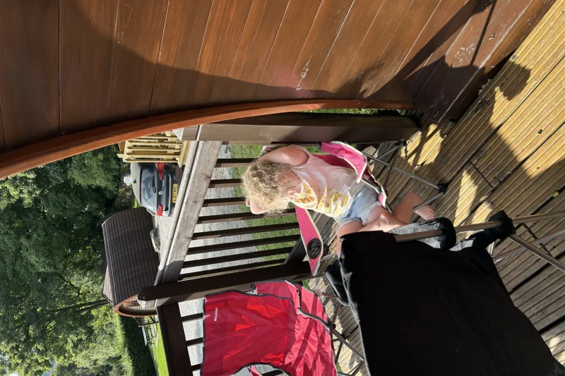 child on decking of camping pod