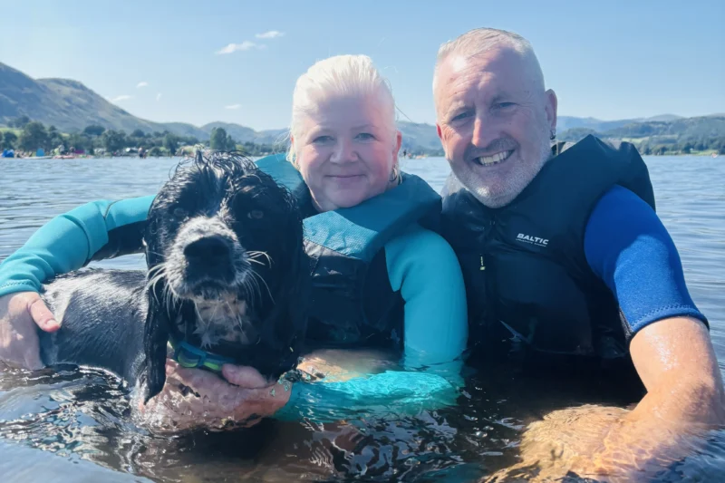 couple and dog swimming in lake district