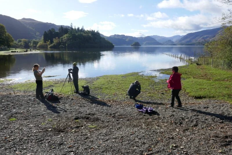 family taking photos by the shore