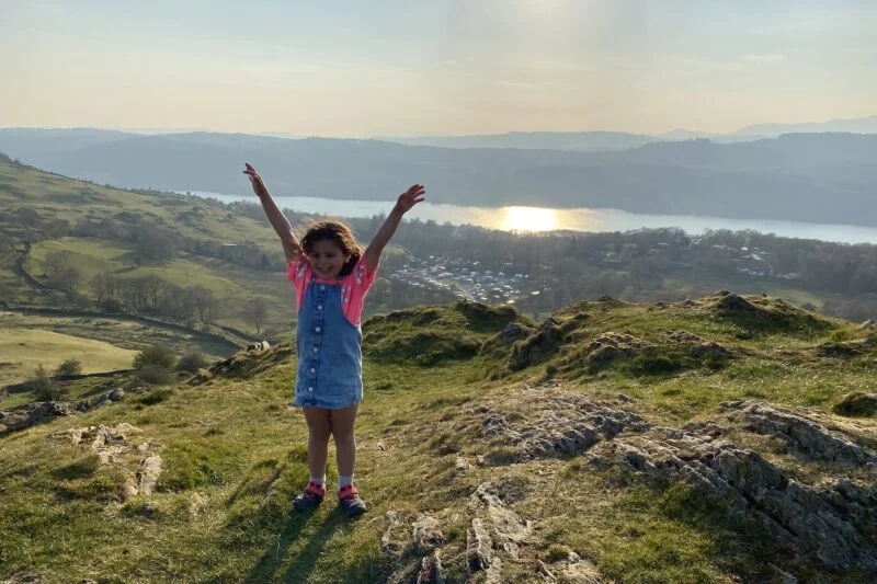 little girl posing with views of lake windermere
