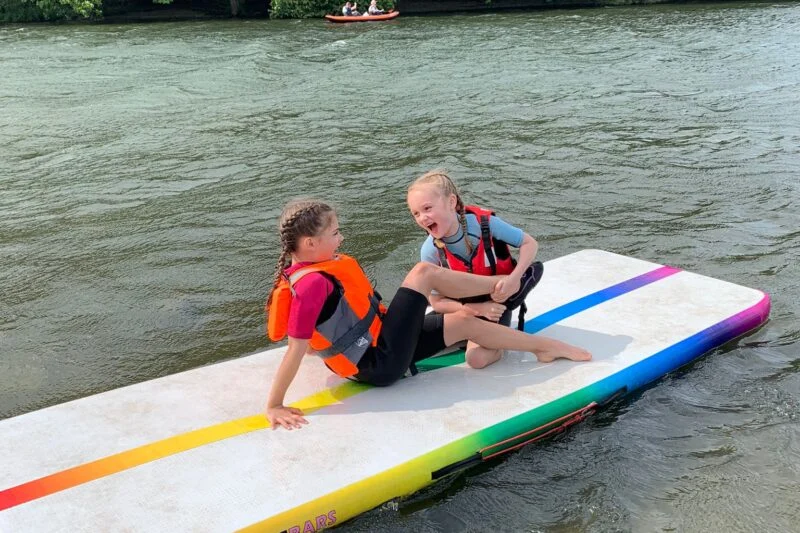 little girls on inflatable lilo in the water