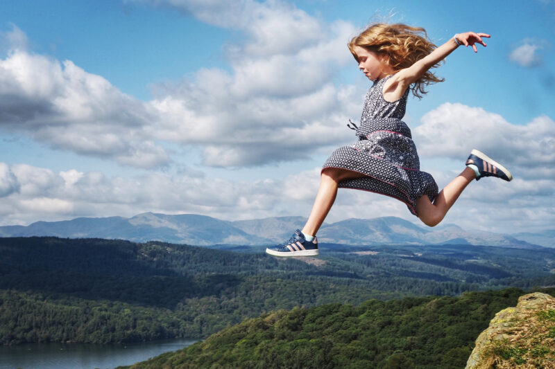 girl jumping off ledge in the lake district