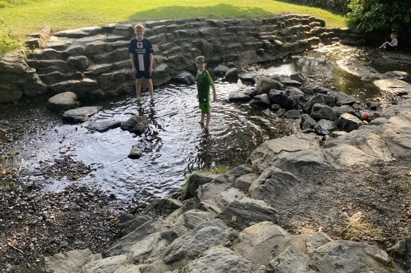 children paddling in the river in the lake district