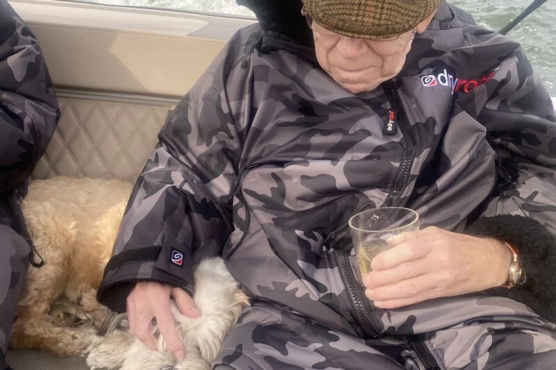 man and dog on boat in the lake district