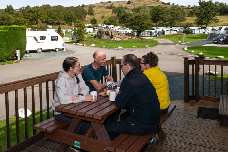 static caravan people sat at bench outside lake district