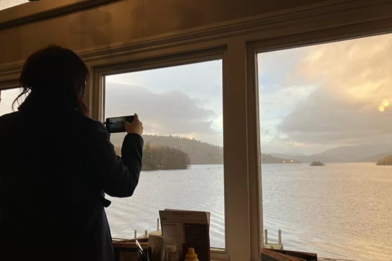 woman taking photos of lake