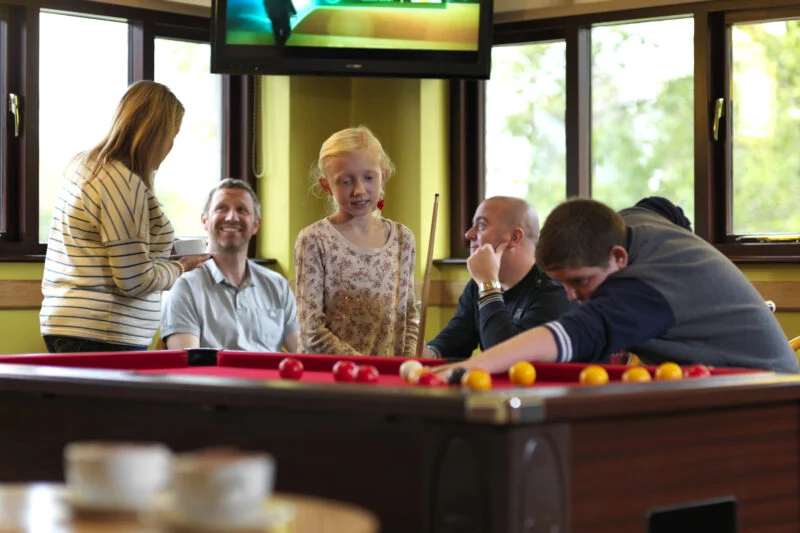 Family playing pool at Park Cliffe holiday park
