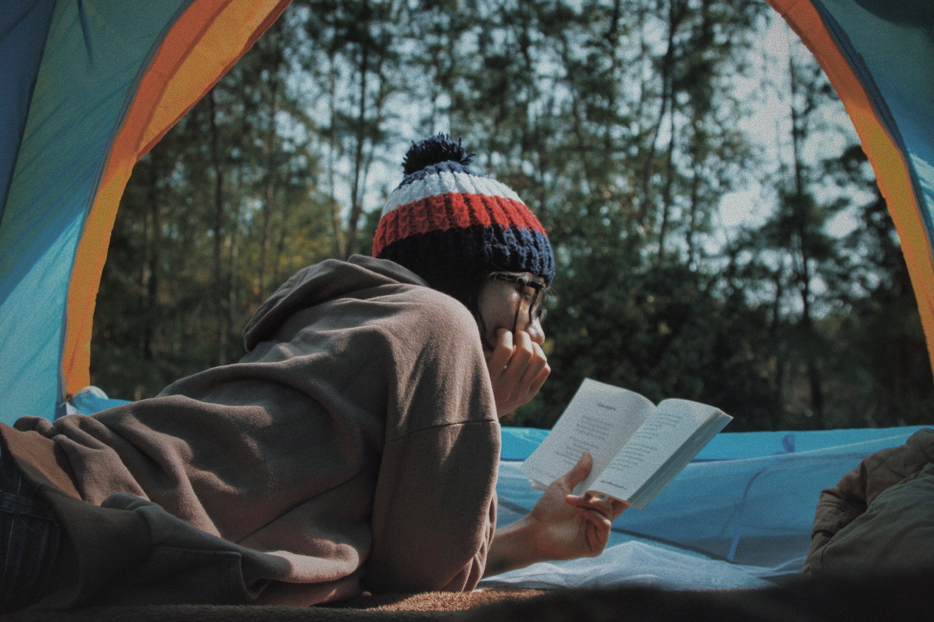 girl reading a book in a tent