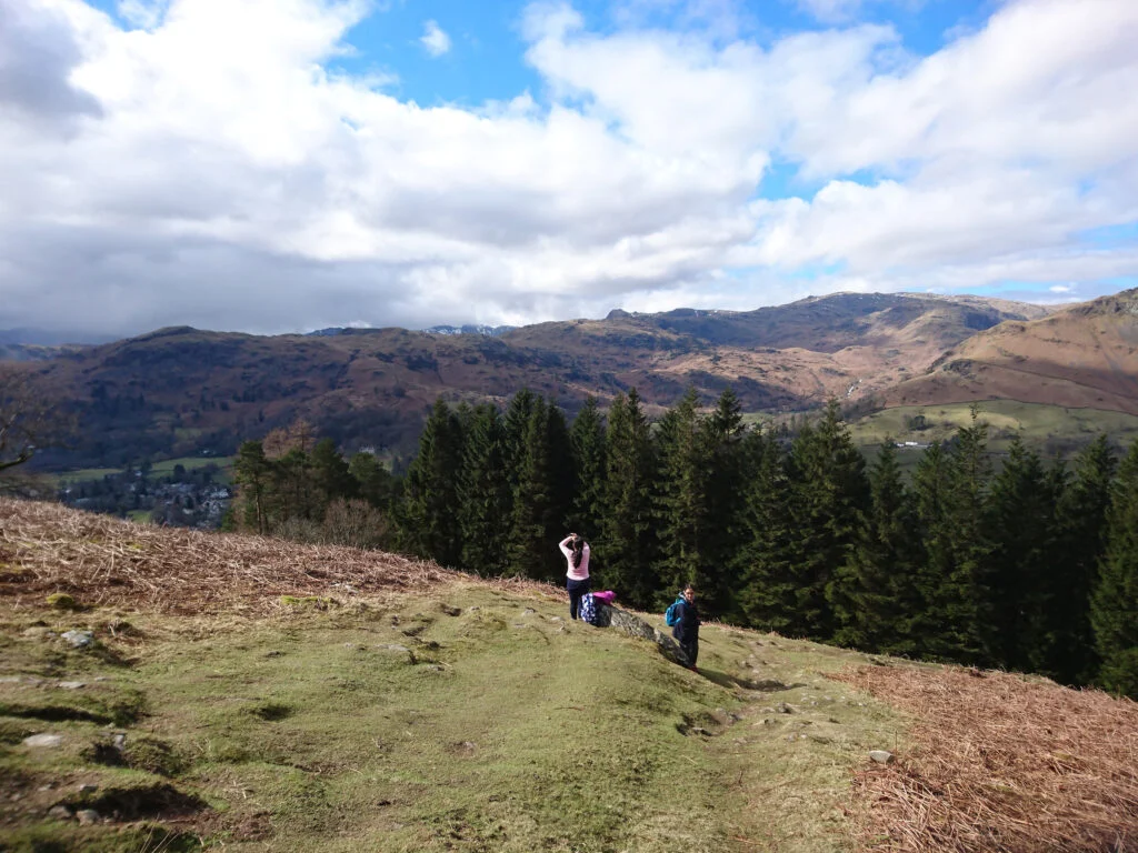 couple taking photos at alcock tarn in grasmere