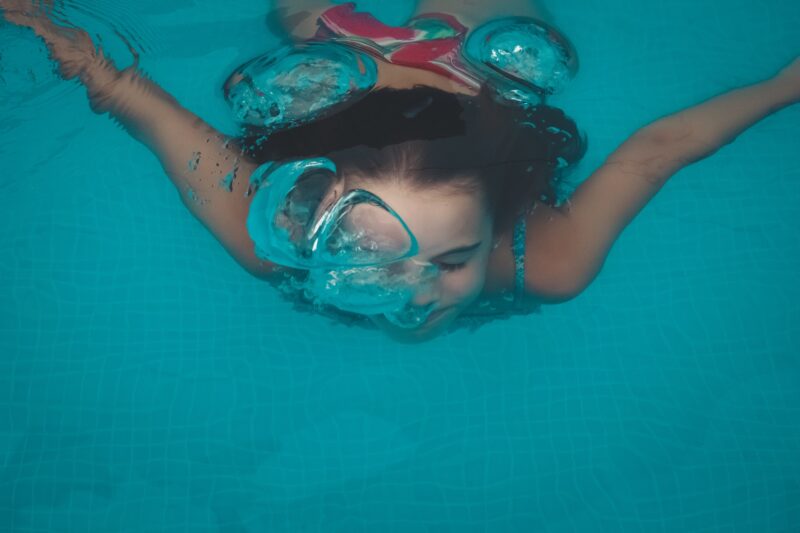 girl swimming underwater in a pool
