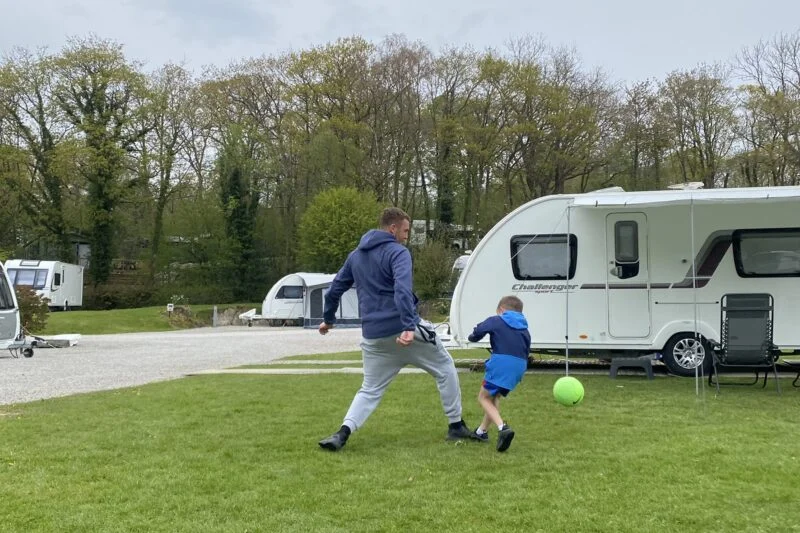 man and boy playing football at park cliffe