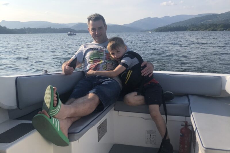 father and son on boat hire lake district
