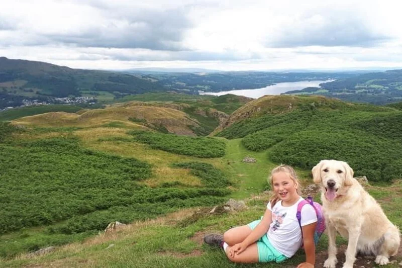 young girl and dog walking in the lake district hills