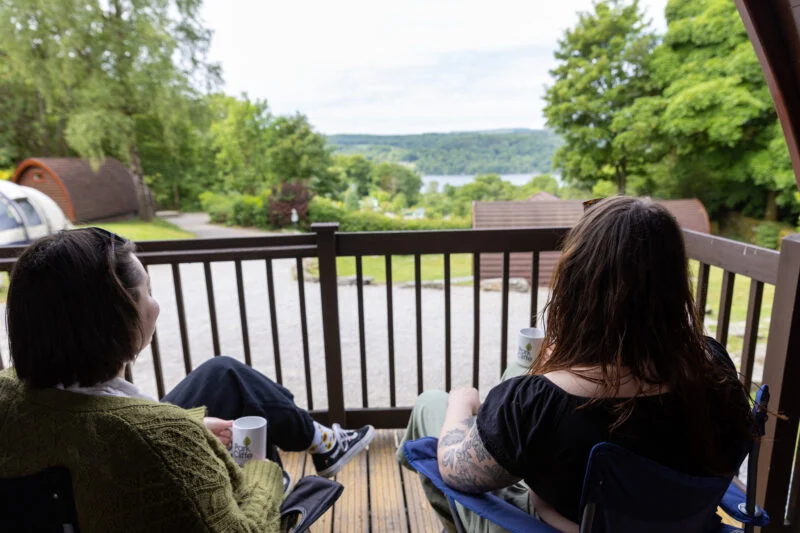 Glamping pod at windermere couple sitting on decking